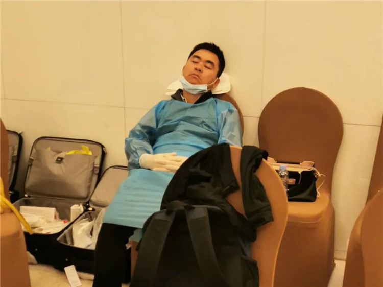连续值守后在采样点椅子上睡着的疾控人员.jpg